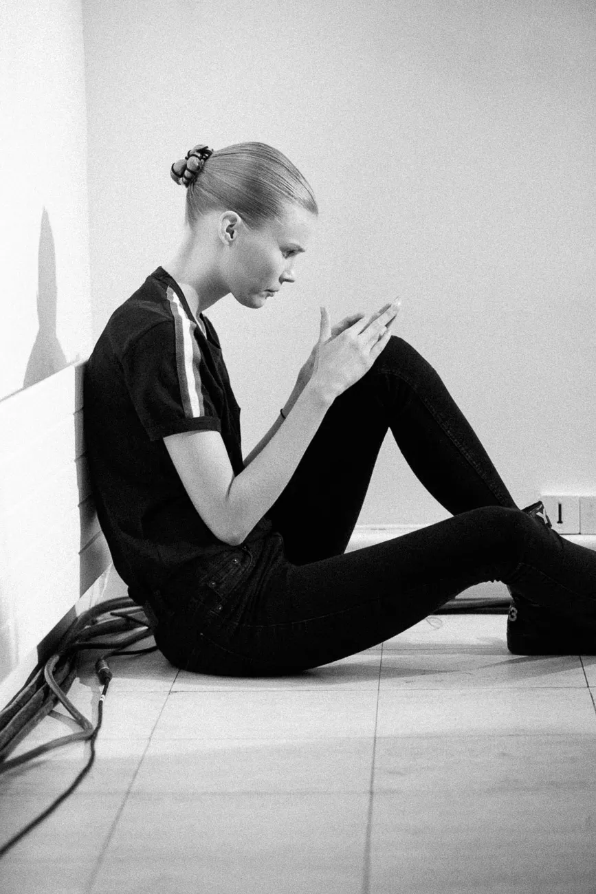 Model black outfit sitting bw - fashion week 2